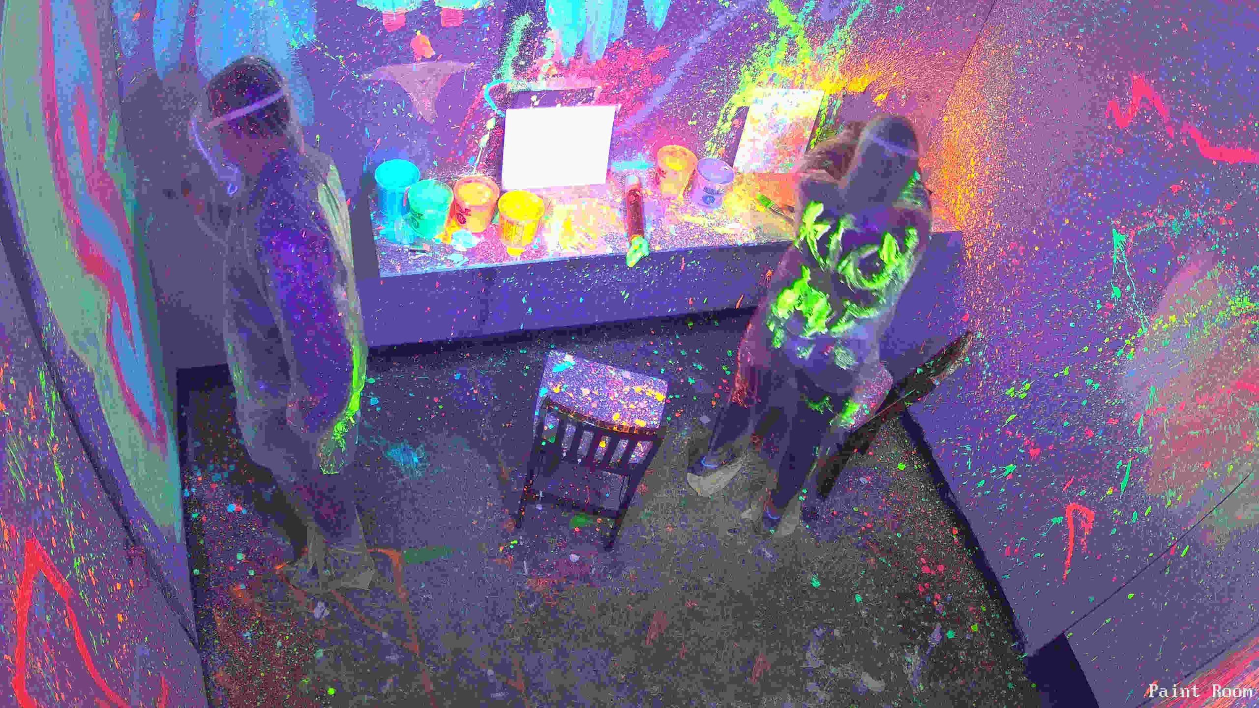 Couple having fun in paint splatter room date night Oceanside