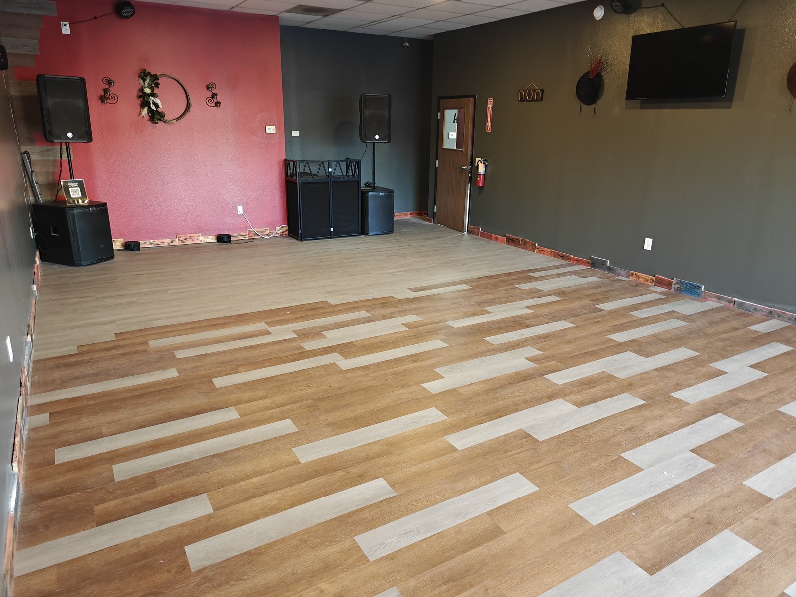 The private party room at Chopscape in Oceanside — open floor, sound system and wall-mounted screen